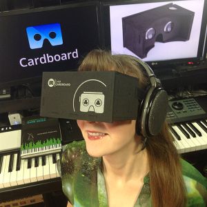 Game composer Winifred Phillips tries out the VR experience of Google Cardboard (pictured here in her music production studio).