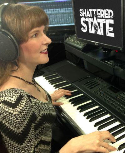 Photo of video game music composer Winifred Phillips working in her music production studio on the musical score of the Shattered State VR game from Supermassive Games.