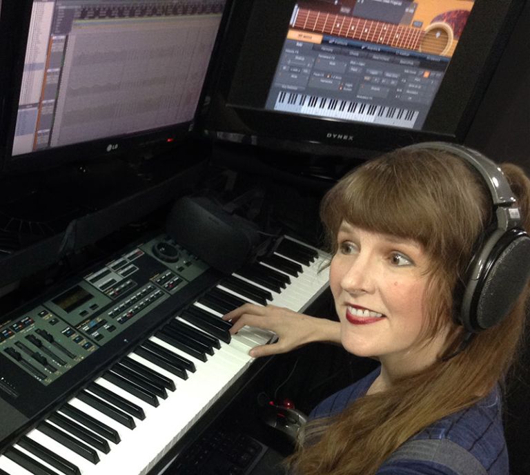 In this article about Virtual Presence in VR written for video game composers, Winifred Phillips (video game composer) is here pictured working in her music production studio.