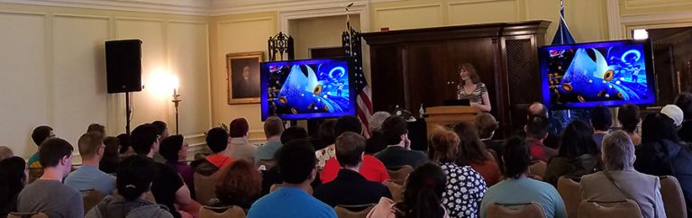 A photo showing Winifred Phillips (popular video game music composer) as she presents the first-ever video game music composition lecture to be given at the Library of Congress (Thomas Jefferson Building, Washington DC).