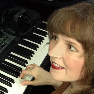 Photo depicting video game composer Winifred Phillips working in her music production studio.