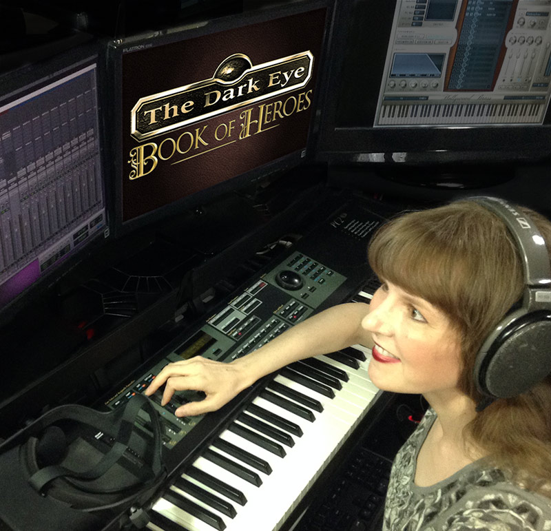 This photo includes game music composer Winifred Phillips working in her production studio. Phillips is the game music composer for The Dark Eye: Book of Heroes game, developed by Random Potion for Wild River Games. Her credits include titles from 5 of the most well-known game franchises, and she is one of the foremost authorities on video game music, having presented lectures at the Game Developers Conference (GDC), the Library of Congress in Washington DC, and the Society of Composers and Lyricists in NYC.