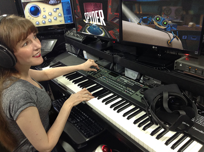 A photo of game music composer Winifred Phillips working in her music production studio on the musical score of the Spyder video game from Sumo Digital.  Winifred Phillips is an award-winning video game composer whose credits include games from five of the biggest franchises in gaming (Assassin's Creed, God of War, Total War, LittleBigPlanet, The Sims).